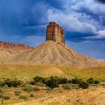 A tall rock formation under a dark cloudy sky